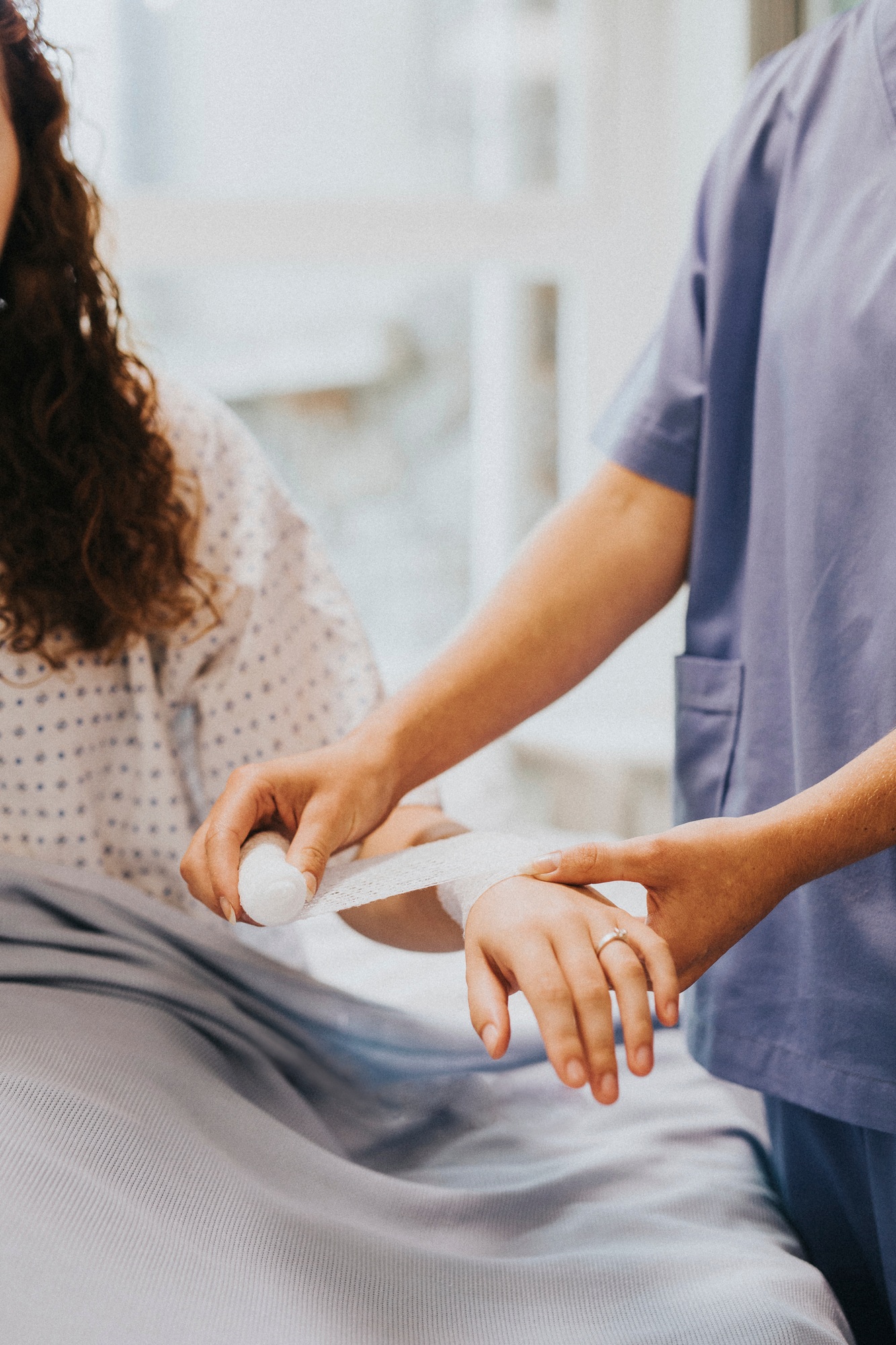 Nurse bandaging a patient's arm