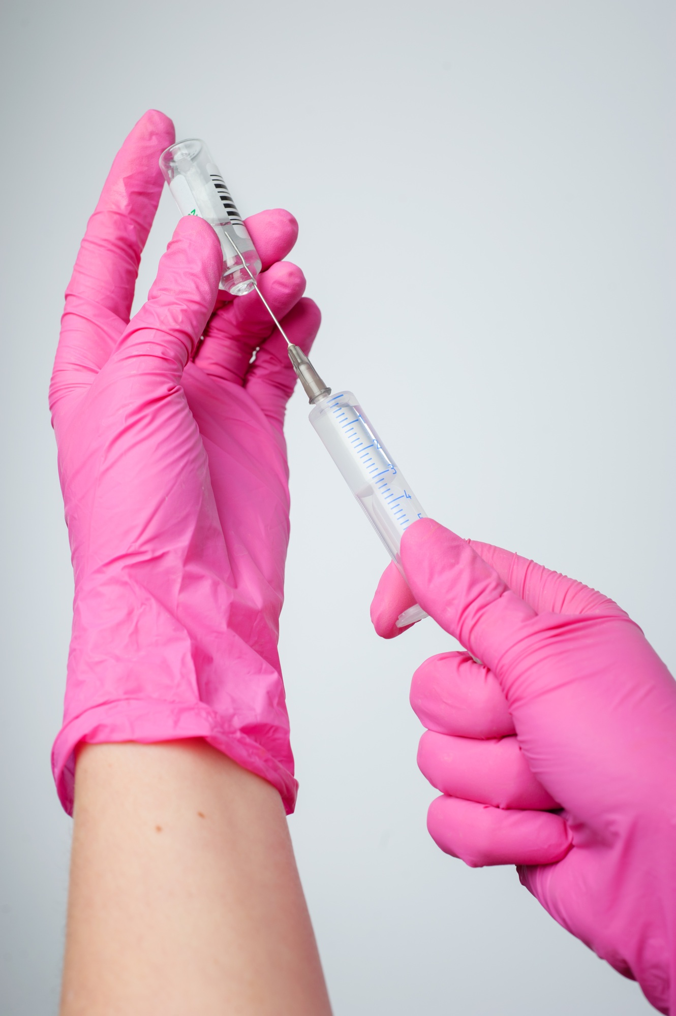 The nurse prepares for the medical procedure by filling the syringe